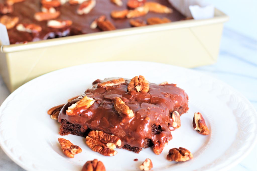 gluten free chocolate cake with icing and pecans
