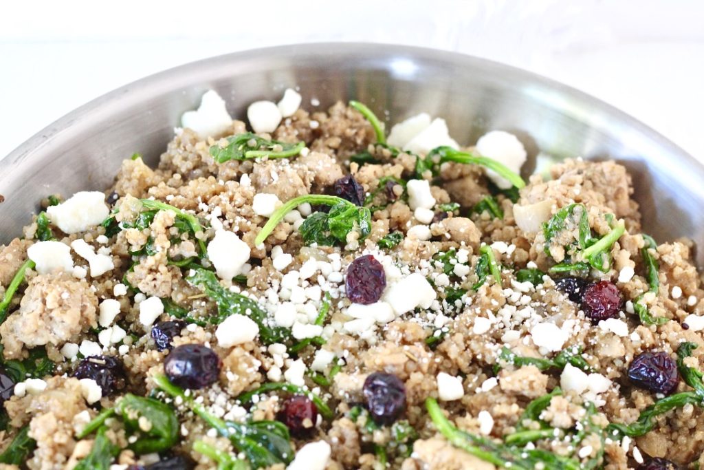 quinoa, cranberries, feta cheese, and spinach in a pan