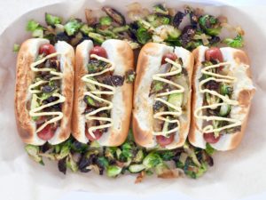 beef hot dogs with toppings on a bed of veggies