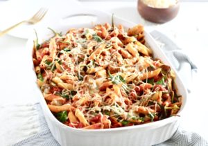 Cheesy Ground Lamb and Spinach Pasta Bake in white baking dish