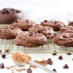 Double Chocolate Fudge Breakfast Cookies on cooling rack with cocoa powder and chocolate chips