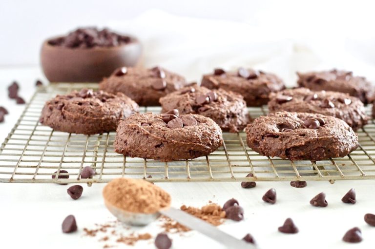 Double Chocolate Fudge Breakfast Cookies | Milk & Honey Nutrition Double Chocolate Fudge Breakfast Cookies on cooling rack with cocoa powder and chocolate chips