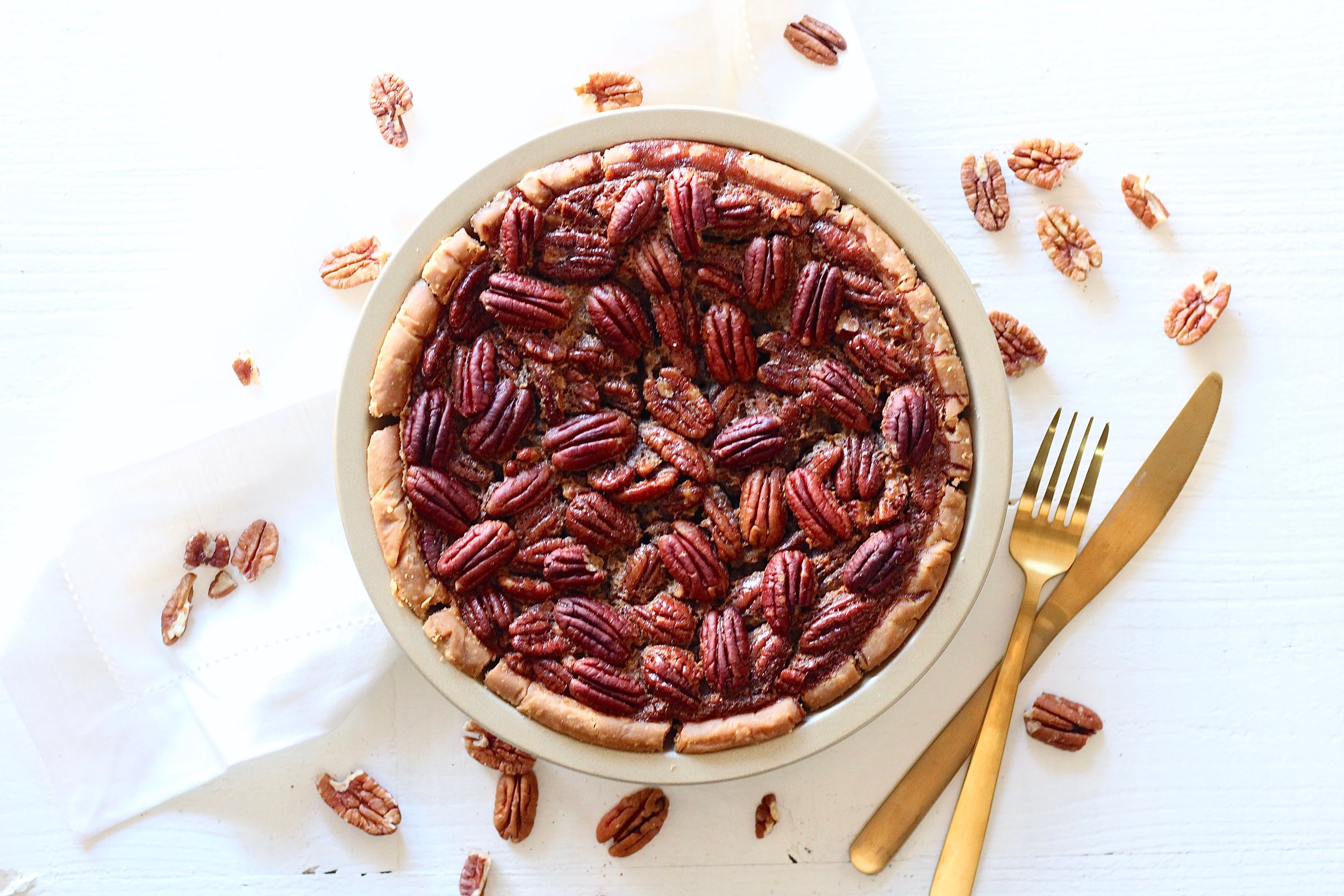 Lower Sugar Pecan Pie | Milk & Honey Nutrition Lower Sugar Pecan Pie on table with pecans