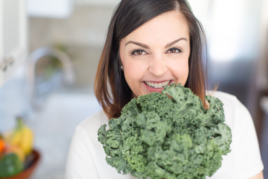 close up picture of Mary Ellen Phipps with a bunch of kale