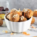 No-Bake Carrot Cake Energy Balls in a bowl with ingredients on counter