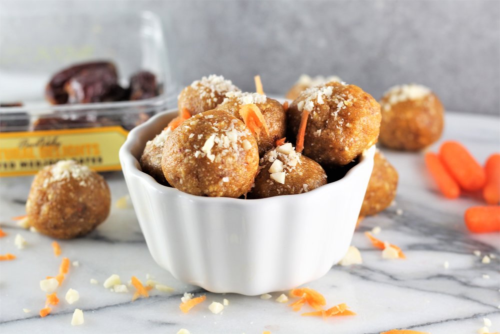 No-Bake Carrot Cake Energy Balls in a bowl with ingredients on counter