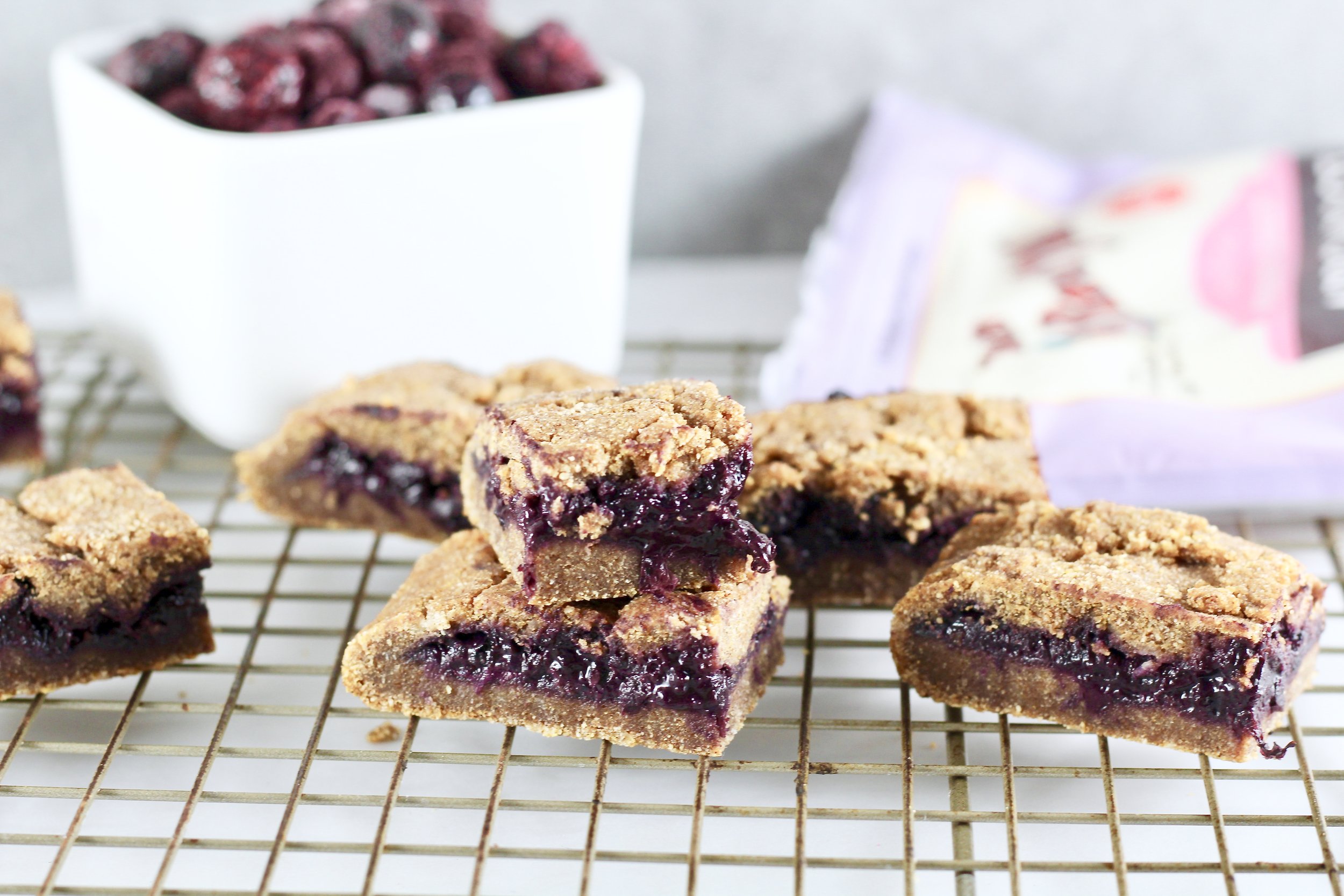 Paleo Blueberry Breakfast Bars on cooling rack with bowl of blueberries and bob's red mill mix