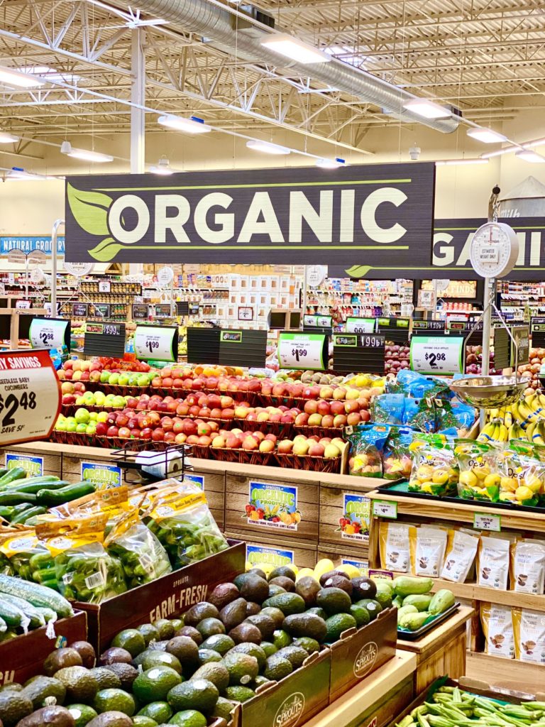 organic produce section at sprouts with apples, avocado, bananas