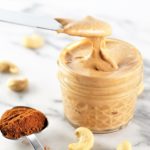pumpkin spice roasted cashew butter with measurement of pumpkin spice on counter