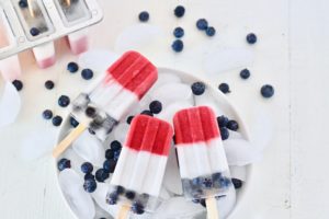 red white and blue fruit popsicles in bowl of ice