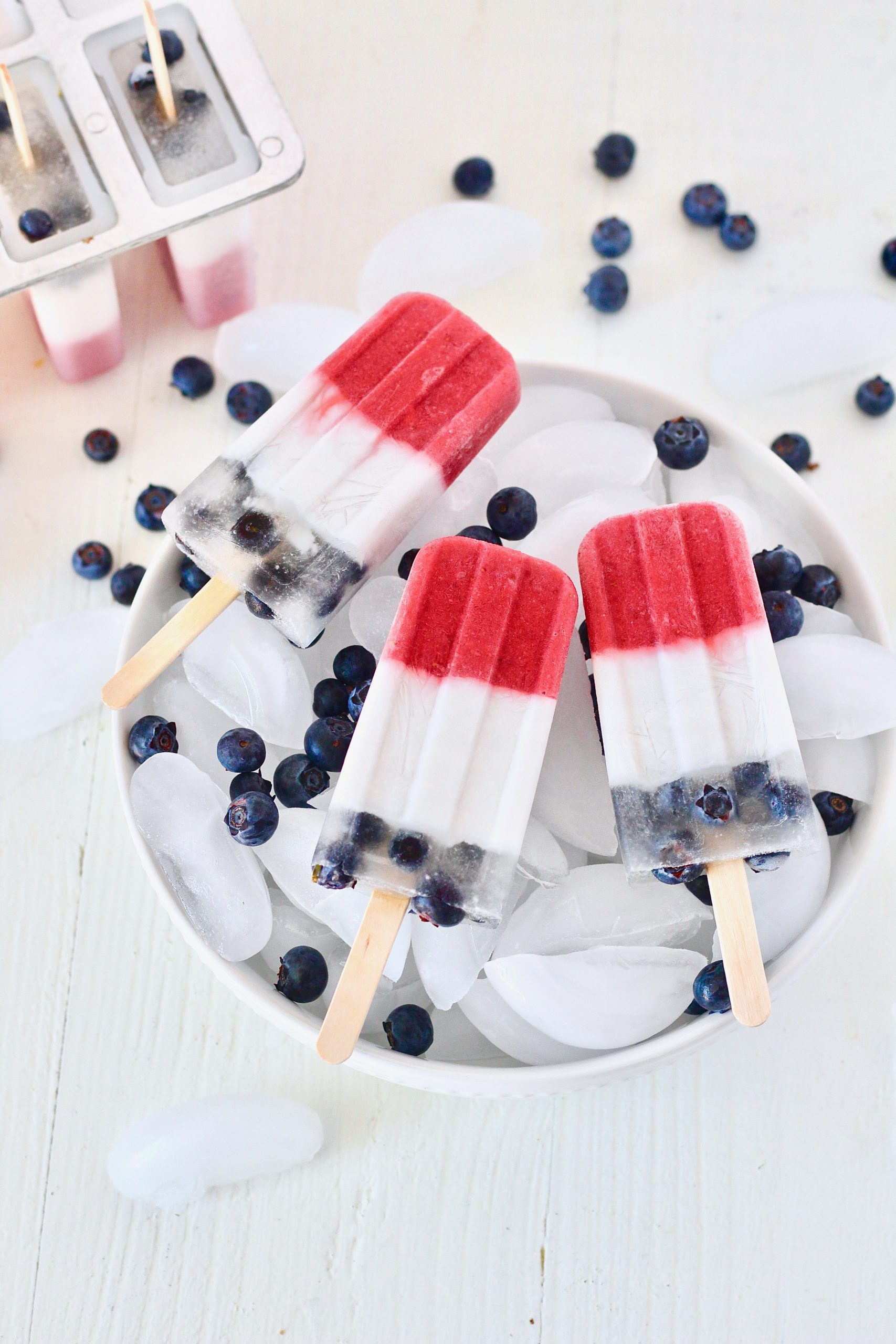 red white and blue fruit popsicles in bowl of ice