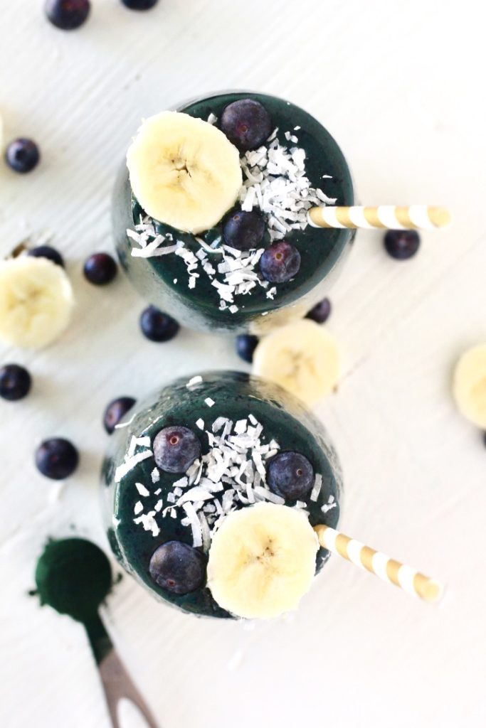 two spirulina smoothies with banana slices and coconut