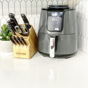 knife block with an air fryer on white quartz countertop