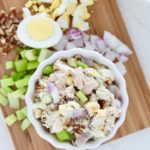tuna salad on cutting board with hard boiled egg onion and celery