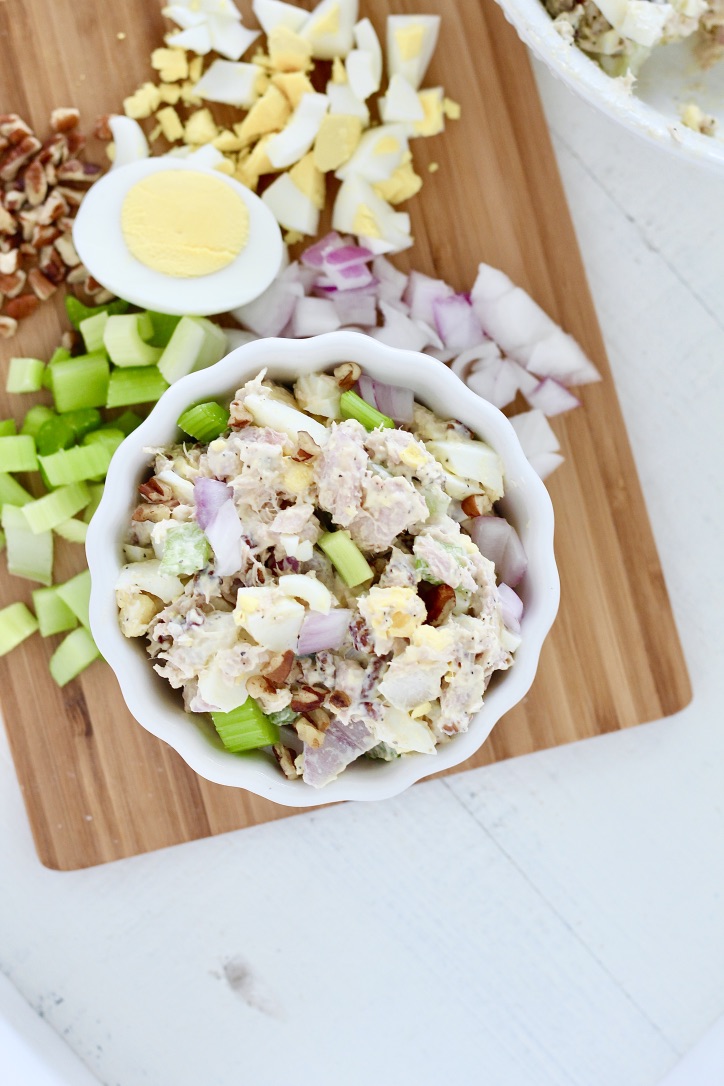 tuna salad on cutting board with hard boiled eggs celery onion and pecans