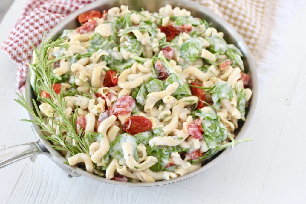 pasta dish in skillet with tea towel