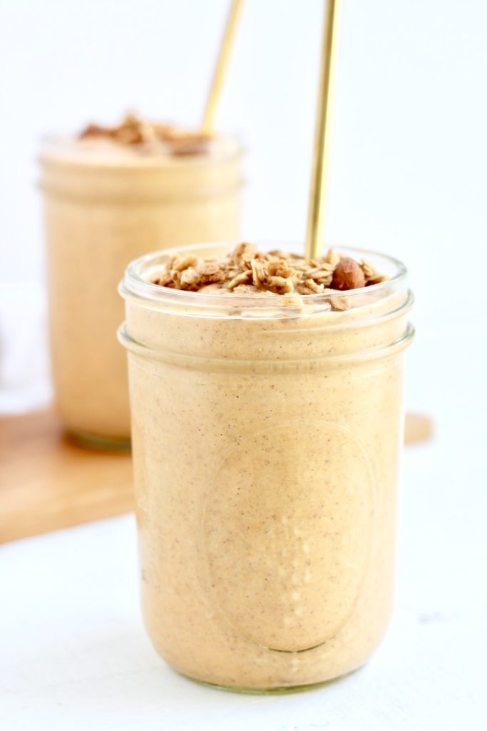 two sweet potato smoothies in mason jars with gold metal straws