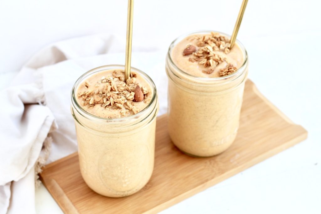 two sweet potato smoothies in mason jars with gold metal straws