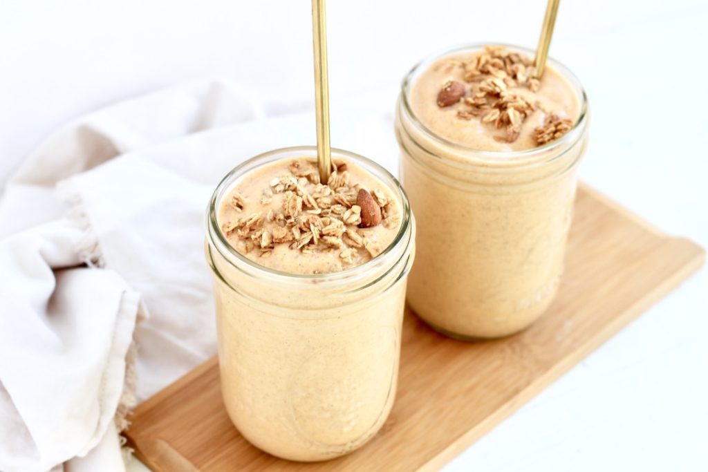 two sweet potato smoothies in mason jars with gold metal straws