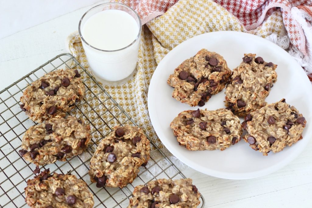 oatmeal chocolate chip bars on cooling rack and on white plate glass of milk