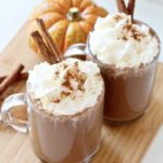 hot chocolate with chipped cream and cinnamon sticks