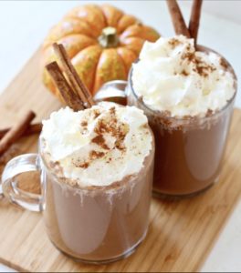hot chocolate with chipped cream and cinnamon sticks