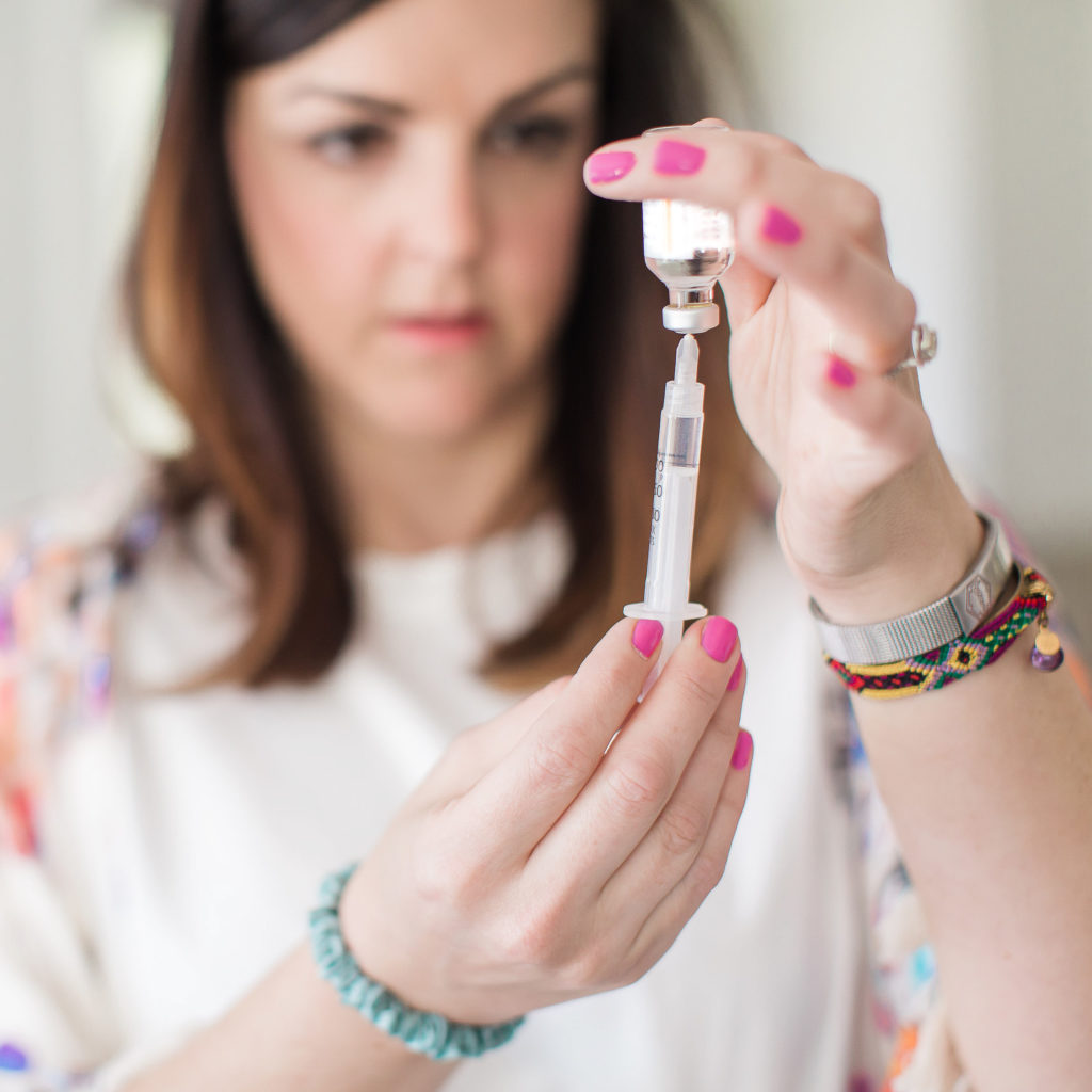 woman drawing up insulin in syringe