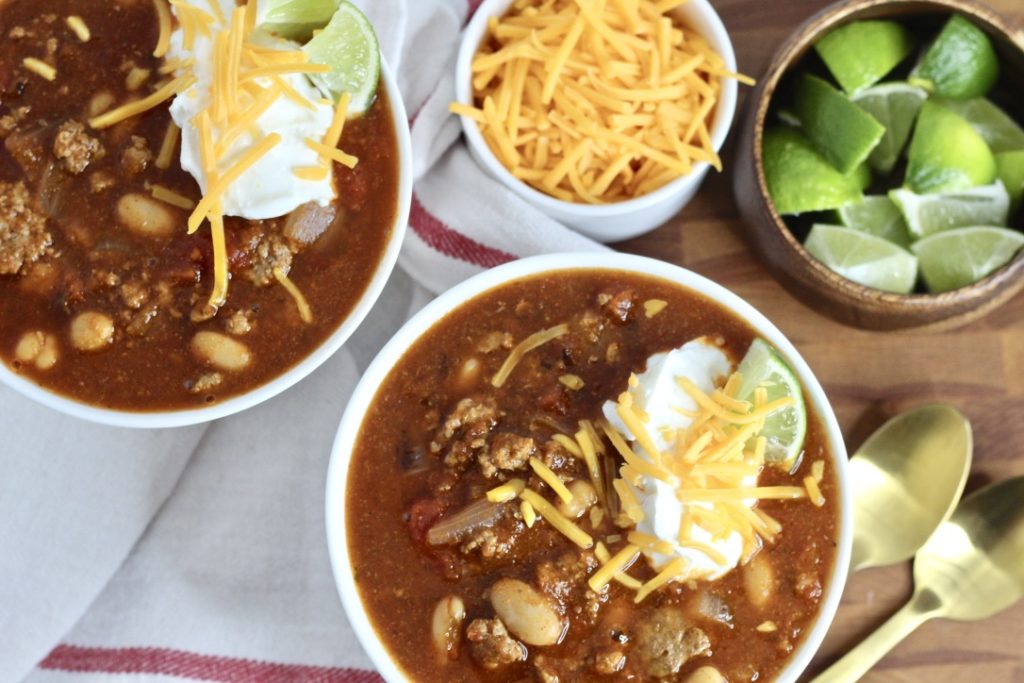 gluten free chili with turkey cheddar cheese and limes in two bowls