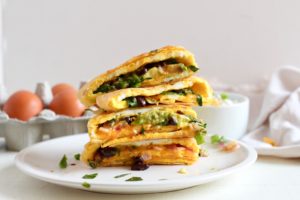 stack of veggie black bean and egg quesadilla on white plate