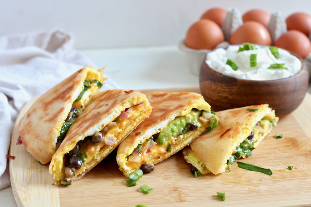 veggies black bean and egg quesadillas on white plate with plain greek yogurt