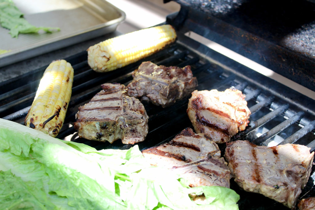 lamb loin chops on grill with corn on the cob and romaine