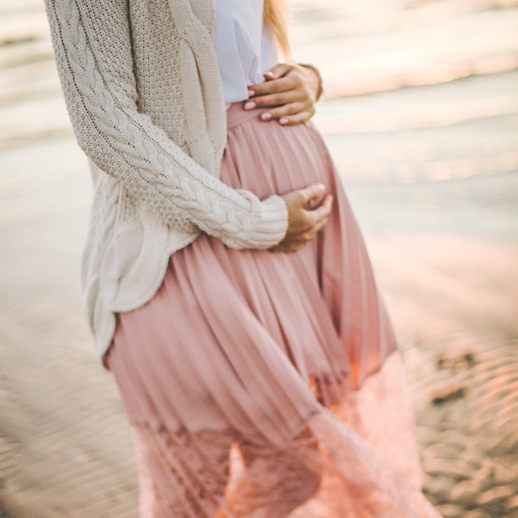 pregnant woman holding belly in pink dress pregnancy  and type 1 diabetes