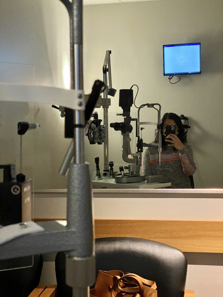 woman waiting for eyes to dilate during routine eye exam