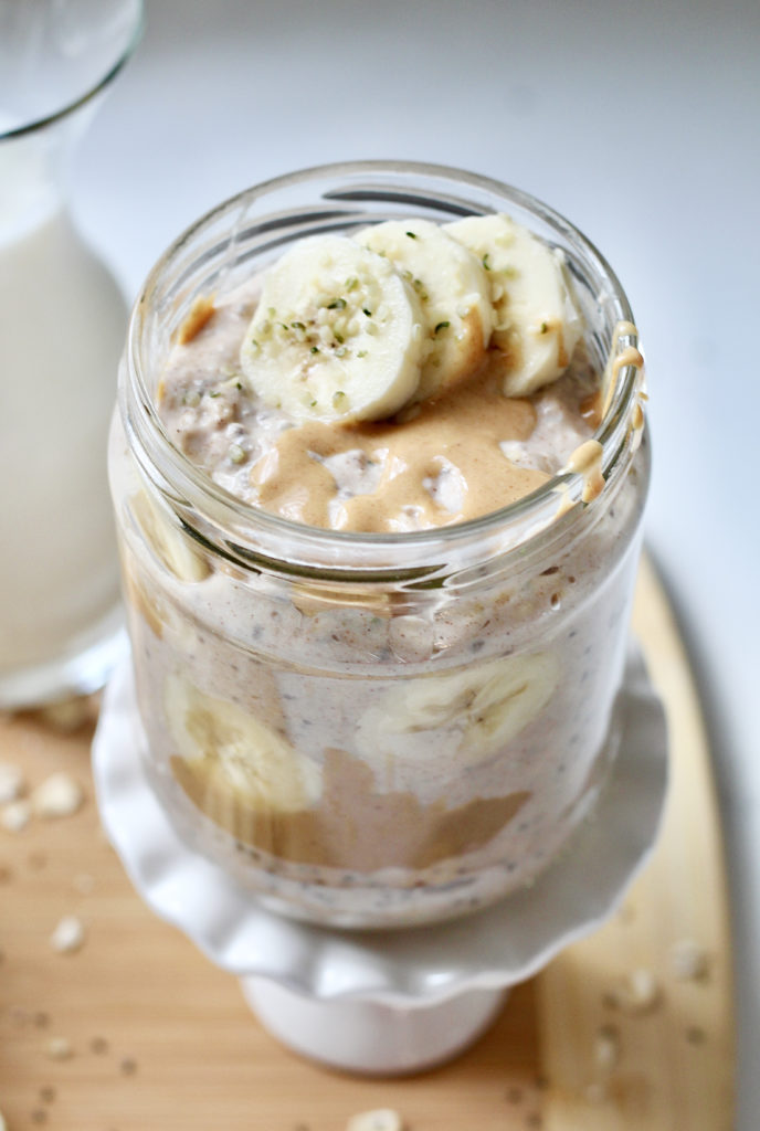 peanut butter overnight oats in glass jar on white cupcake stand