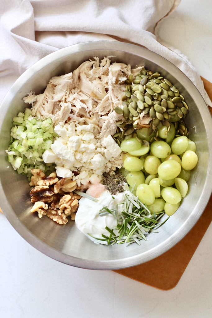 ingredients for chicken salad with grapes and walnuts in stainless steel bowl