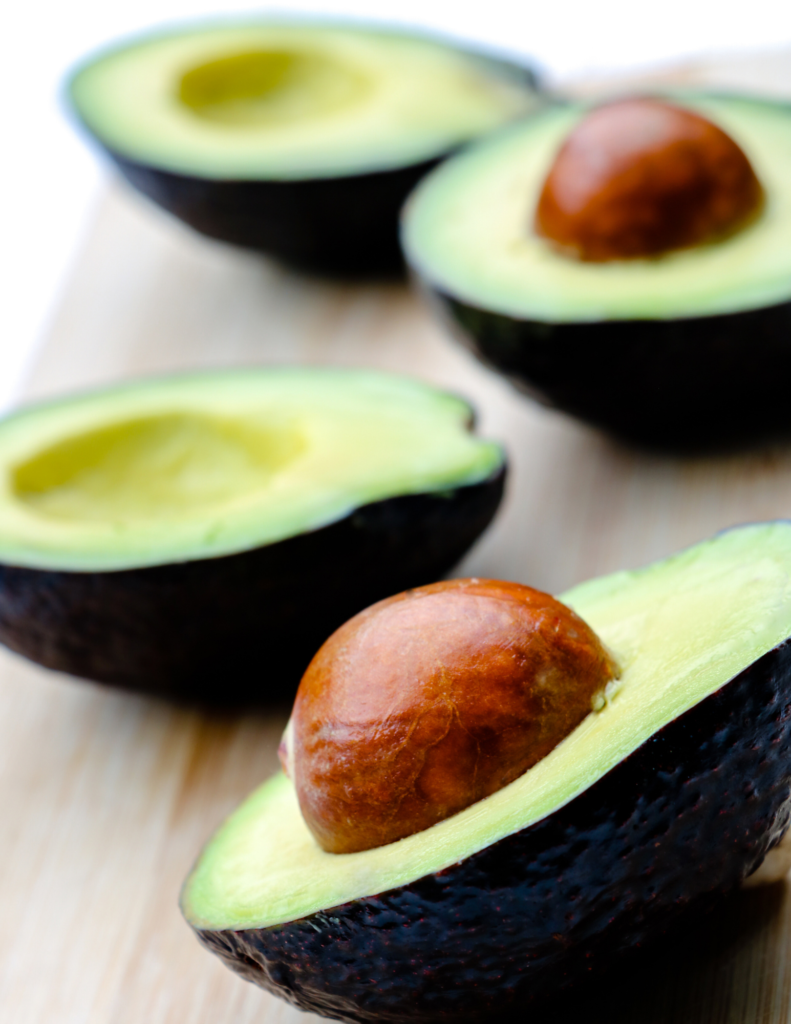 What foods help lower blood sugar avocado | Milk & Honey Nutrition sliced avocados with pit