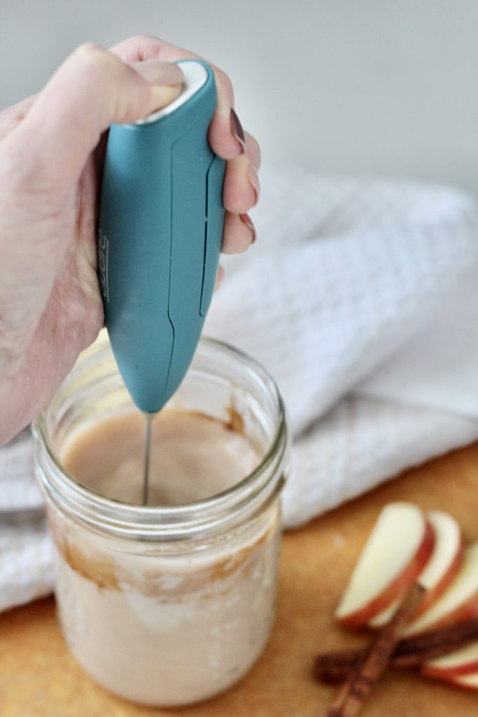 stick frother foaming whole milk in mason jar