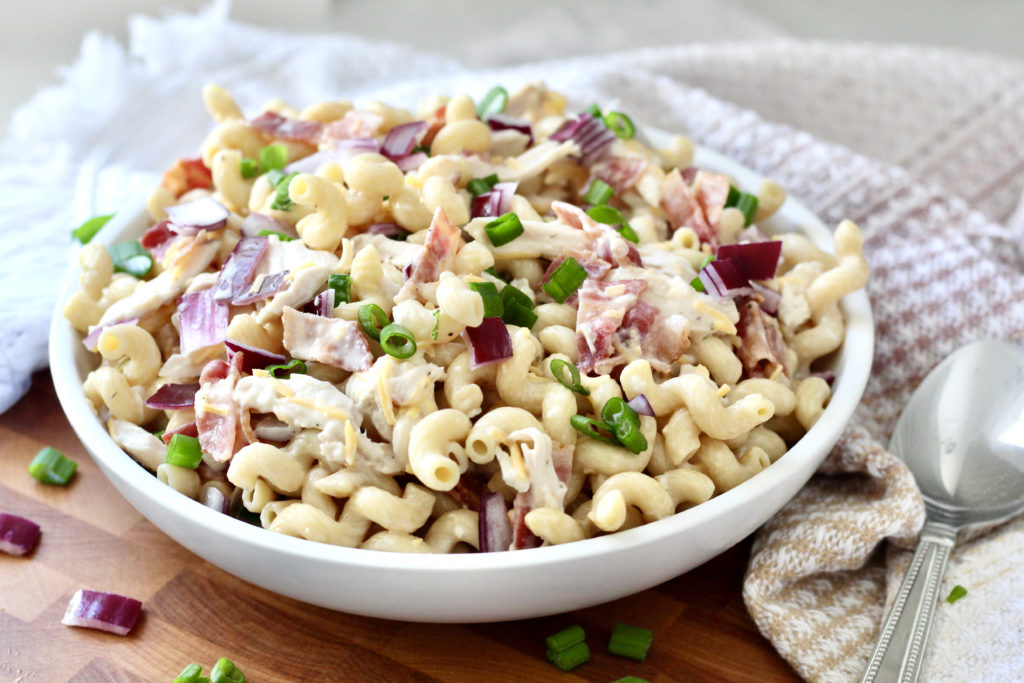 pasta salad with chicken bacon ranch dressing onions in white bowl