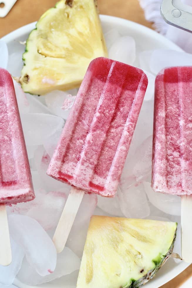 pineapple cherry popsicles and pineapple slices in bowl of ice
