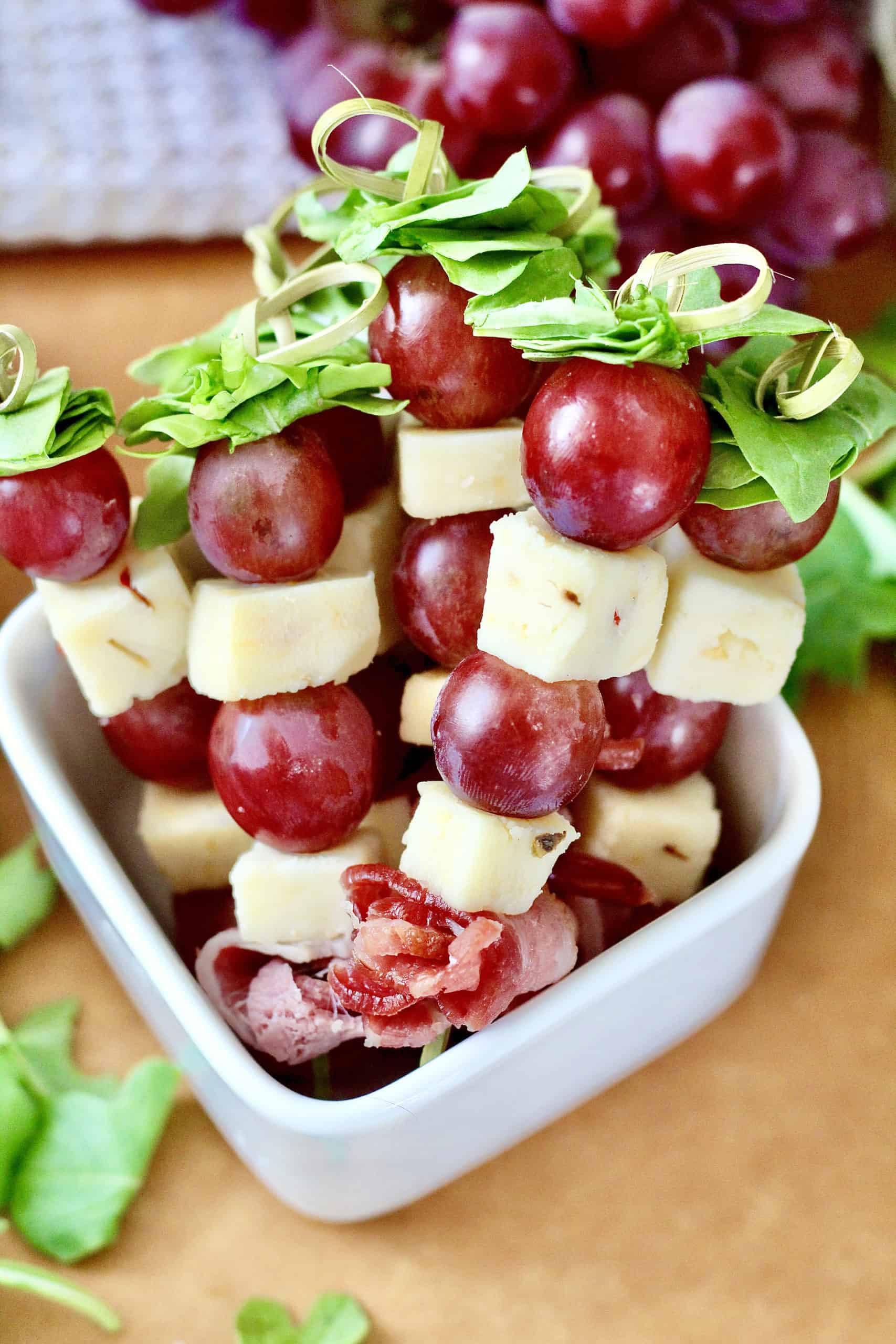 pepperjack cheese and grapes skewers with red grapes in white bowl