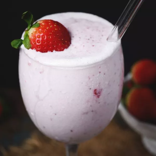 low carb strawberry smoothie in glass with straw