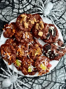 sugar free halloween candy clusters on white marble platter with silver glitter spiders